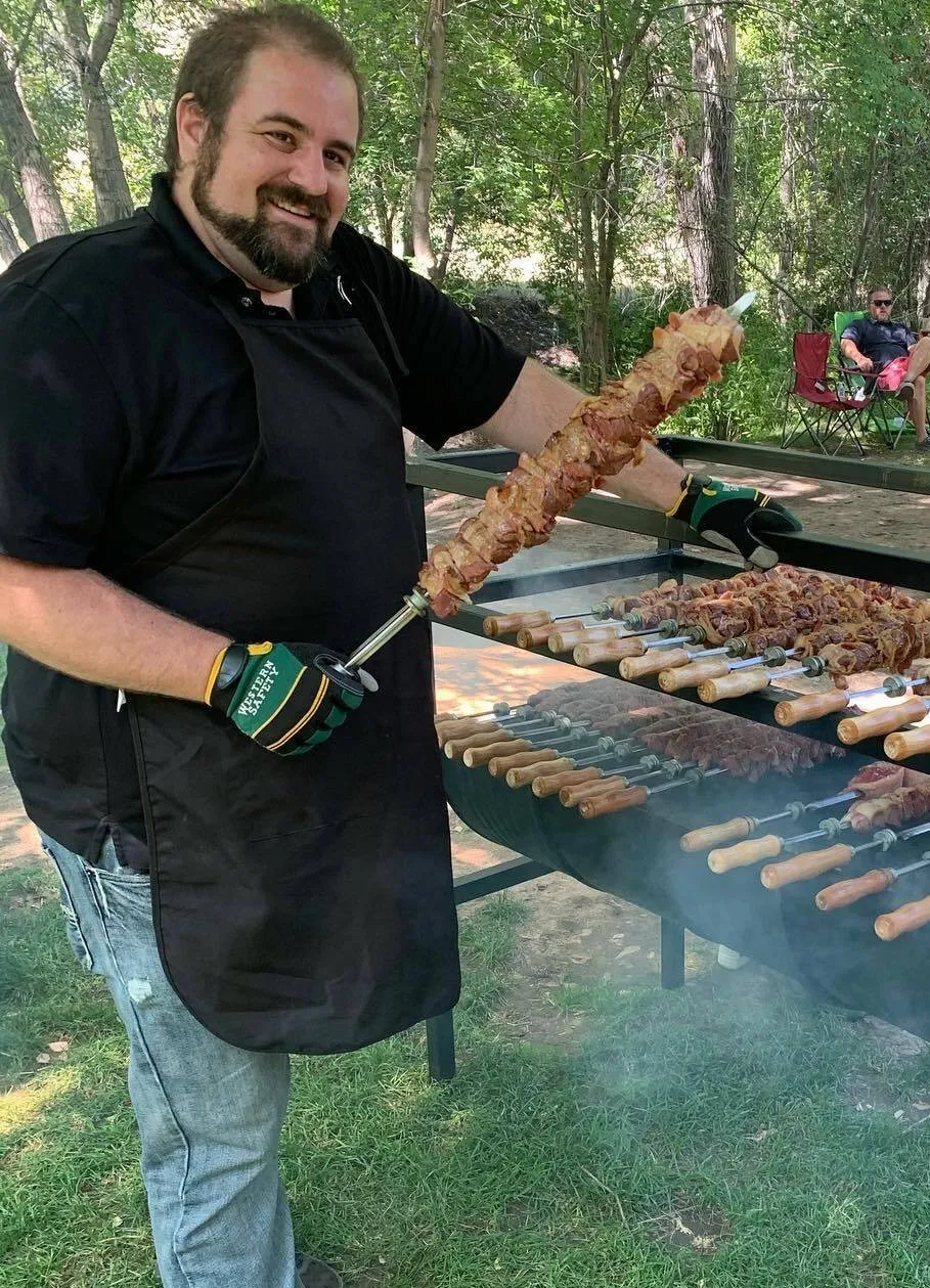 Chef standing beside the custom churrasqueira
